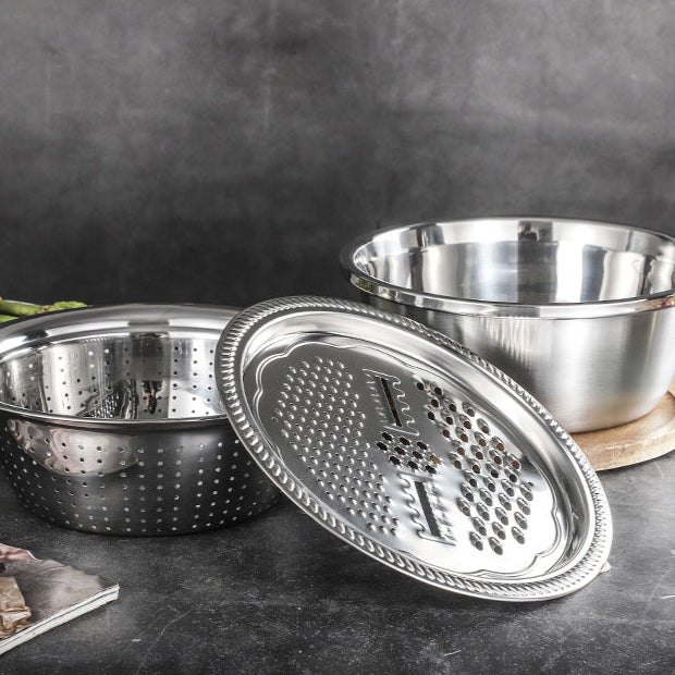 Stainless steel grater and bowl set on a dark surface with a blurred background